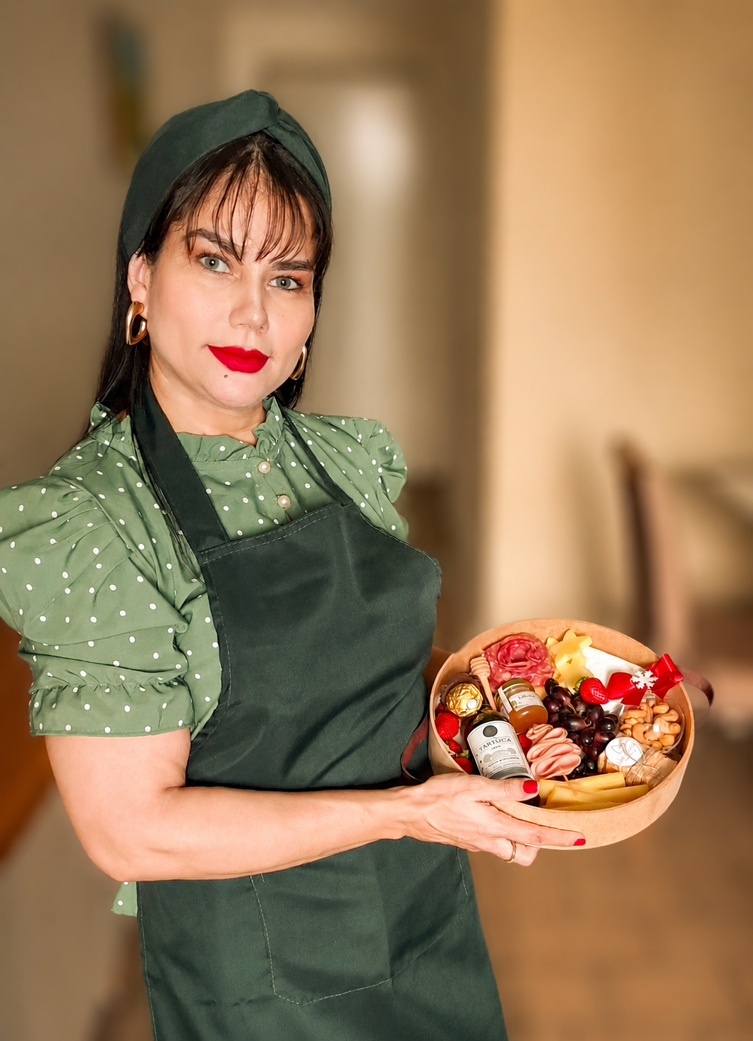 Mãos preparando arranjo de flores e doces em caixa